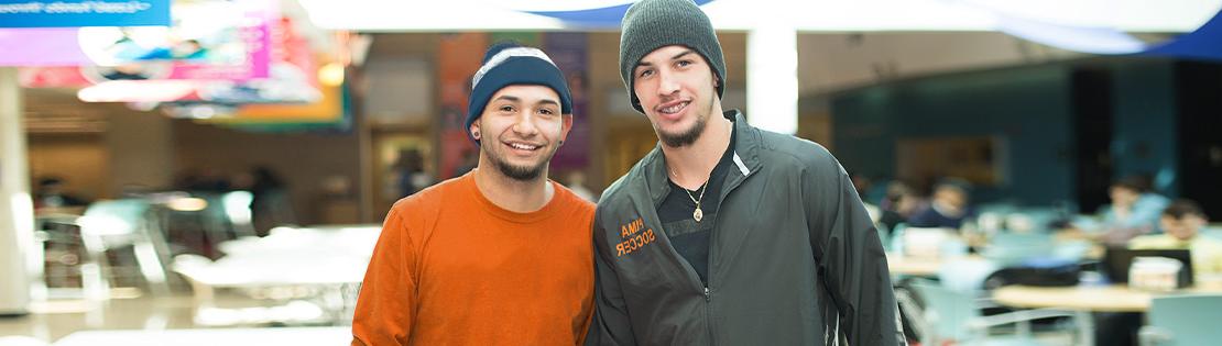 Students pose and smile in a student lounge at West Campus