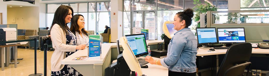 A Student Services Employee helps some students at Pima's Downtown Campus